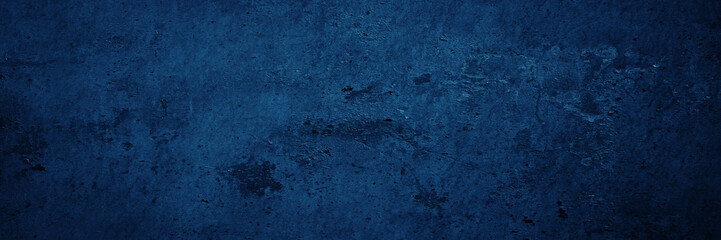 Fototapeta na wymiar Dark blue grunge texture. Toned rough wall surface. Background with space for design. Web banner. Wide. Panoramic.