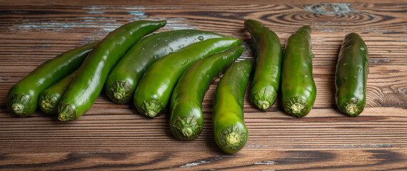 Green ripe hot chili pepper on wooden background
