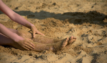 Kids at the Beach.  Sand sticks to the wet feet of kids having fun on a very warm Spring Day in Upstate NY.
