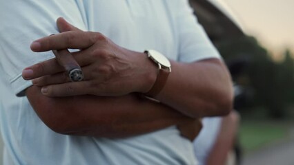 Man hand smoking cigar by golf cart. Rich couple enjoy resting in golfing car. - Powered by Adobe