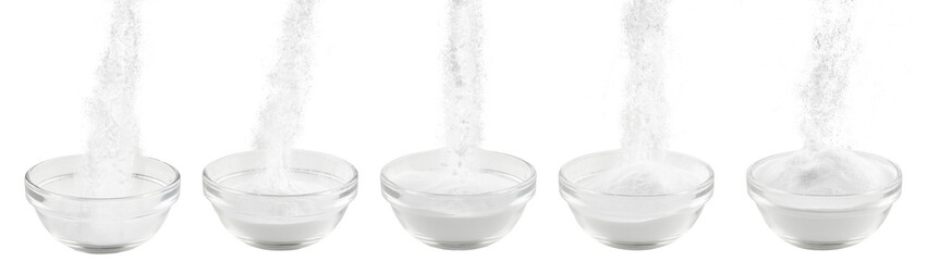 Soda in a glass bowl. Soda, flour, salt or sugar is poured into a glass container. Five plates with white powder on a white background. - 506836613