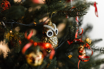 Christmas owl vintage toy hanging on Christmas tree with lights