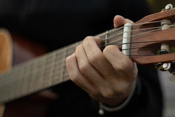 The guy plays the old guitar. Guitar in hands. Close-up strings. 