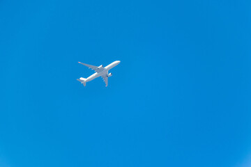 Fototapeta na wymiar 青い空を飛ぶ白い飛行機
