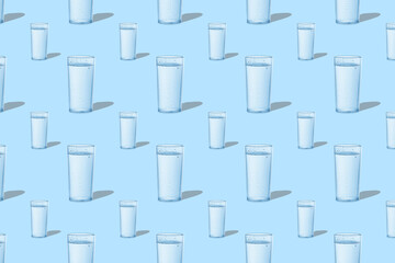 Fototapeta na wymiar Pattern from glasses with water on blue background. The concept of summer icy drink.