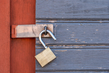 Old unlocked padlock on a wooden door