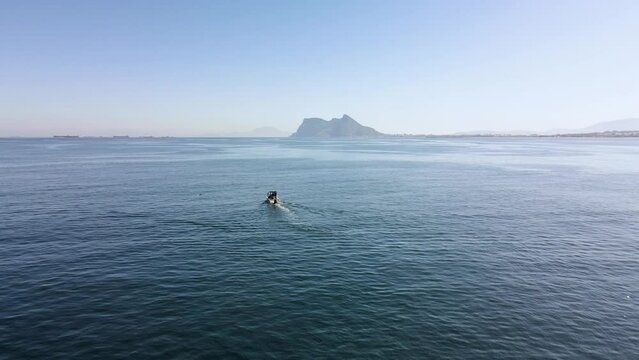 Navigating in the ocean with the rock of Gibraltar in the background. Aerial footage. British territory of Gibraltar, near Spain. 4K footage.