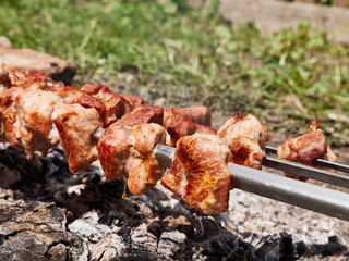 Cooking meat skewers on an open fire. Summer vacation outside the city.