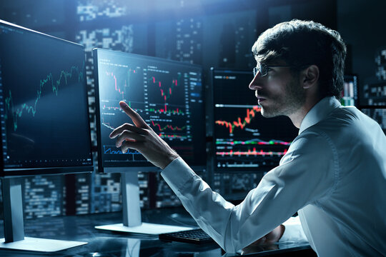 financial analyst pointing at the computer monitor .