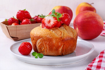 Semolina cake or mannik topped with apple, strawberry and mint. Fruits and berries in the background on the white table. Soviet cuisine dessert