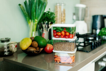 Fresh various vegetables and buckwheat in a container are on the table in the kitchen, the food is ready to eat.