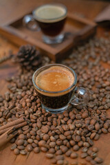 Coffee cup with coffee beans on wood background.