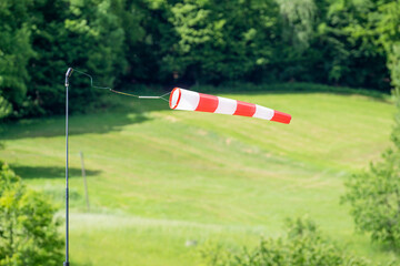Windsock with red and white stripes flaps in the wind