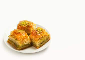 baklava with pistachios, 3 pieces, on a white plate, on a light background, side view, copyspace