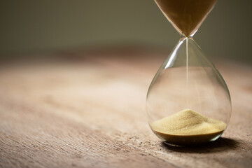 hourglass (sand clock) on an old wooden table, deadline for doing business, elapsed time concept,...