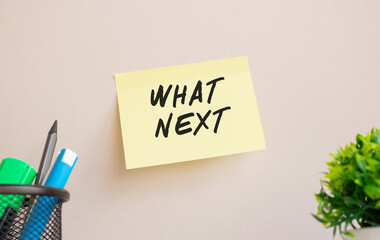The sticker is glued to the wall in the office. There is a reminder on the sticker. WHAT NEXT text...