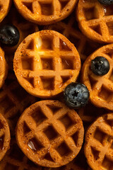 Soft round fried waffles on a beige background. Monochrome pattern with hard shadows.