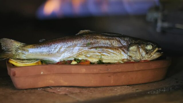 A fish cooked in clay in a traditional oven. Amazing food. 4K. Seafood dish with vegetables. 4k