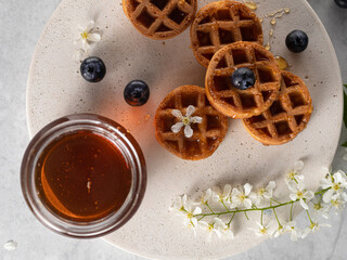 homemade belgian waffels with blueberry and honey on marble table. Vertical