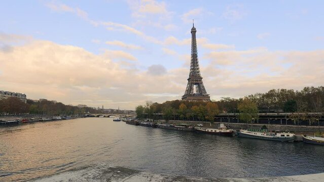 Beautiful view of Eiffel Tower at sunset. Orange, pink and purple sky along the river. Paris, France