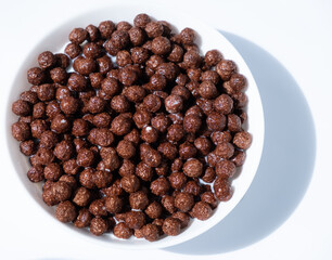 chocolate granules balls in milk in a white plate for breakfast
