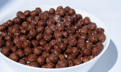 chocolate granules balls in milk in a white plate for breakfast
