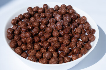 chocolate granules balls in milk in a white plate for breakfast
