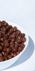 chocolate granules balls in milk in a white plate for breakfast
