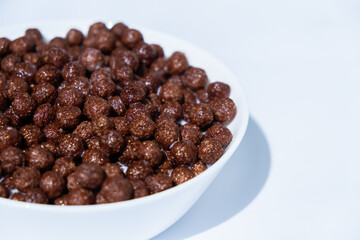chocolate granules balls in milk in a white plate for breakfast
