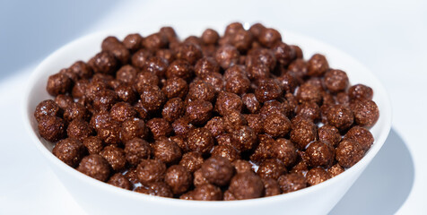 chocolate granules balls in milk in a white plate for breakfast

