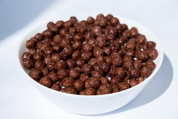 chocolate granules balls in milk in a white plate for breakfast
