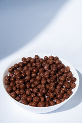 chocolate granules balls in milk in a white plate for breakfast
