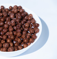 chocolate granules balls in milk in a white plate for breakfast
