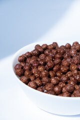 chocolate granules balls in milk in a white plate for breakfast
