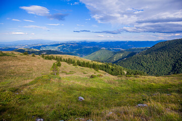 Fototapeta premium Summer Countryside Mountain Nature Landscape. Picturesque Scenery Green Hills And Fields. Beautiful Blue Sky With Clouds. Visually Attractive View.