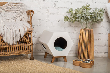 A cozy corner for a pet: a pet house, bowls for food and drink.