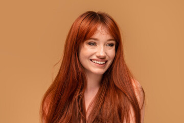Authentic cheerful ginger girl with beautiful smile, natural freckles, long hair and fringe....