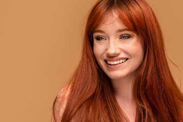 Authentic cheerful ginger girl with beautiful smile, natural freckles, long hair and fringe....