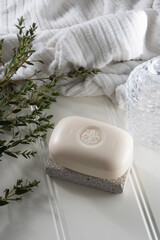 Soap bar and eucalyptus on white spa towel 