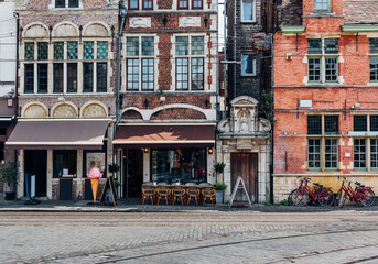 Old street with tables of cafe in Ghent (Gent), Belgium. Architecture and landmark of Ghent. Cozy...