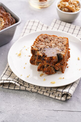 Slices of Chocolate banana bread with walnuts on a checkered kitchen napkin and ingredients on a grey neutral background