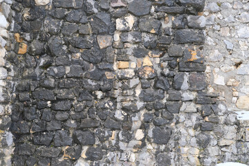 beautiful vintage texture of the wall of a medieval castle built in the middle of the 14th century, multi-colored volumetric stones for the designer, wallpaper, background