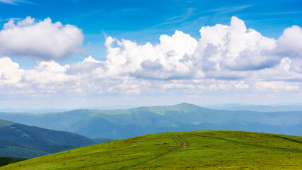 green landscape in dappled light. grassy hills of carpathian mountain scenery on a sunny day. sky with clouds above horizon