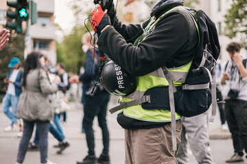 Faceless journalist filming at a demonstration in Berlin
