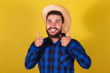 Man wearing typical clothes for Festa Junina. thumb up, positive, affirmative, close-up photo.