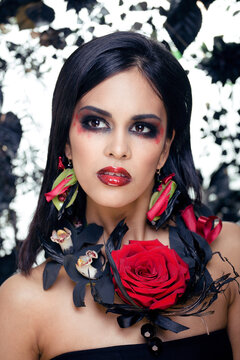 pretty brunette woman with rose jewelry, black and red, bright make up like a vampire closeup red lips