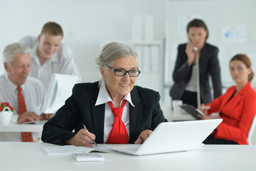 Portrait of a senior woman with a laptop in office