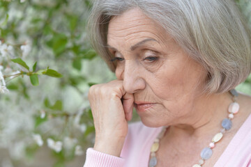 sad senior beautiful woman in park