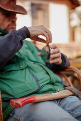 Fototapeta premium Man sits in chair and opens flask