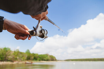 Fisherman hands holding  fishing rod close-up